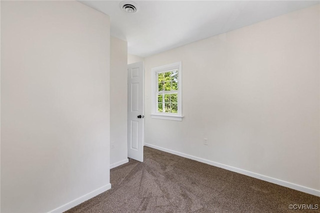 carpeted spare room with visible vents and baseboards