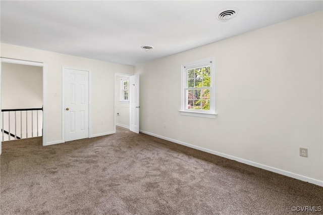 carpeted spare room with baseboards and visible vents