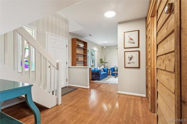 interior space with light wood-style flooring, baseboards, and stairs