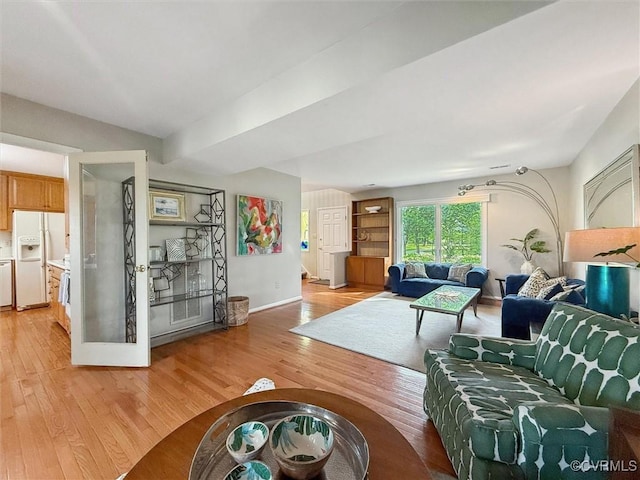 living area featuring light wood finished floors and baseboards
