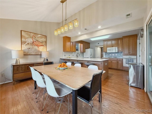 dining space featuring light wood-type flooring and visible vents