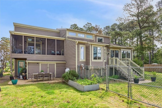 back of house with fence private yard, a patio area, a sunroom, and a lawn