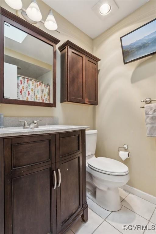 bathroom featuring tile patterned floors, toilet, baseboards, and vanity