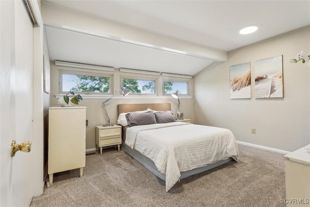carpeted bedroom with multiple windows, baseboards, and vaulted ceiling with beams