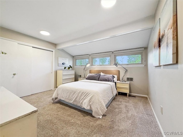 bedroom featuring lofted ceiling with beams, a closet, and carpet