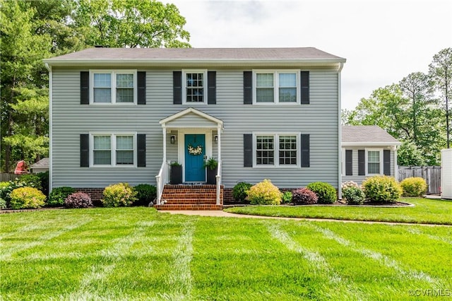 colonial house with a front lawn and fence
