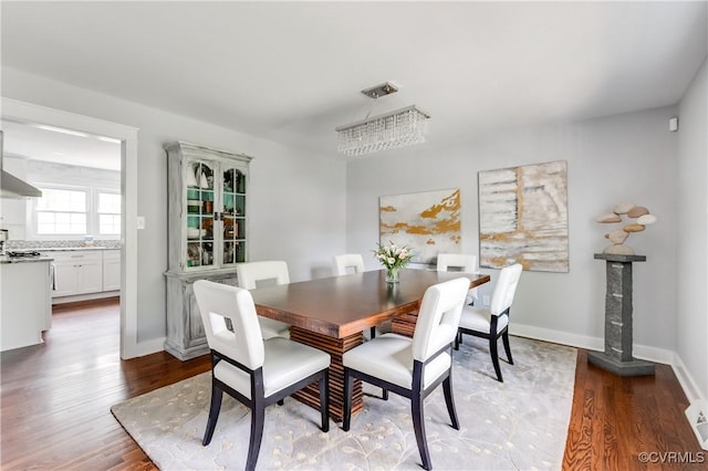 dining area with baseboards and wood finished floors