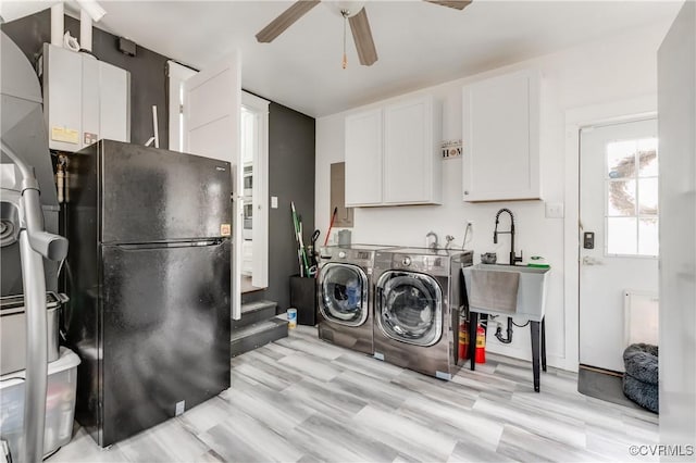 washroom featuring ceiling fan, a sink, separate washer and dryer, laundry area, and light wood-type flooring