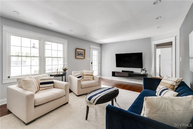 living room featuring baseboards, light wood-style floors, and recessed lighting