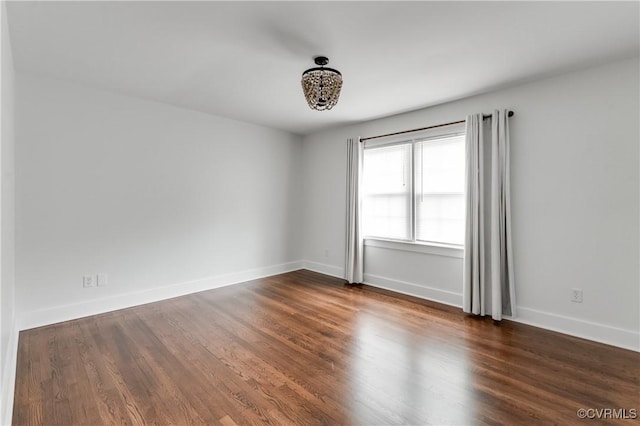empty room with baseboards and wood finished floors