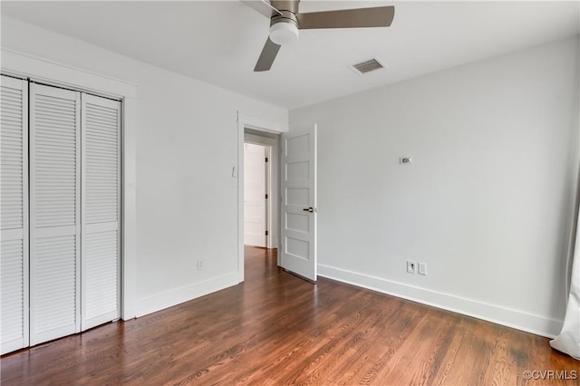 unfurnished bedroom featuring a closet, baseboards, visible vents, and wood finished floors