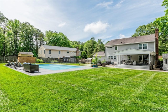 rear view of house with a fenced backyard, a shed, an outdoor hangout area, an outbuilding, and a fenced in pool