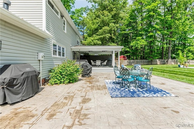 view of patio with a grill, outdoor dining area, and fence