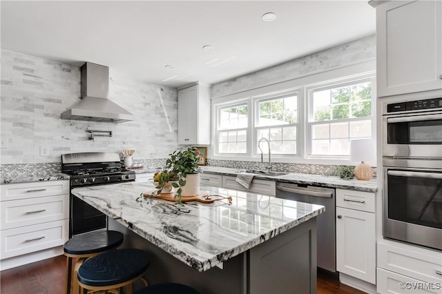 10102 Cherrywood Dr, Richmond, VA 23238 - kitchen with wall chimney exhaust hood, appliances with stainless steel finishes, a kitchen island, a kitchen breakfast bar, and light stone counters