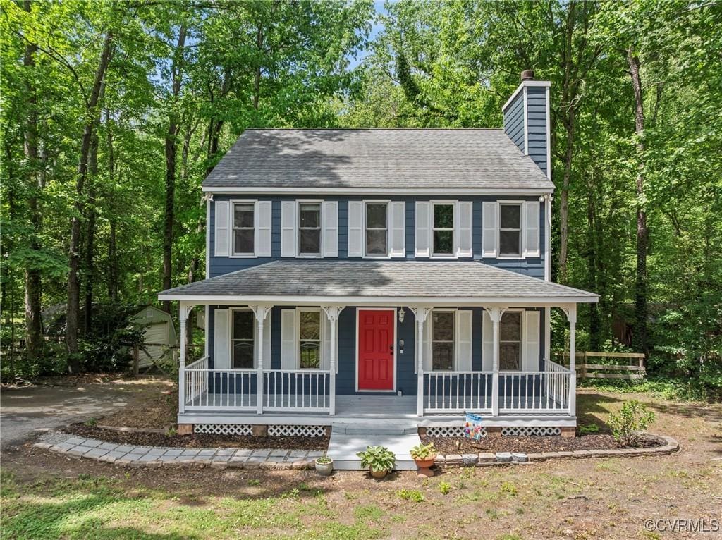 view of front of property with a chimney, a porch, and a shingled roof
