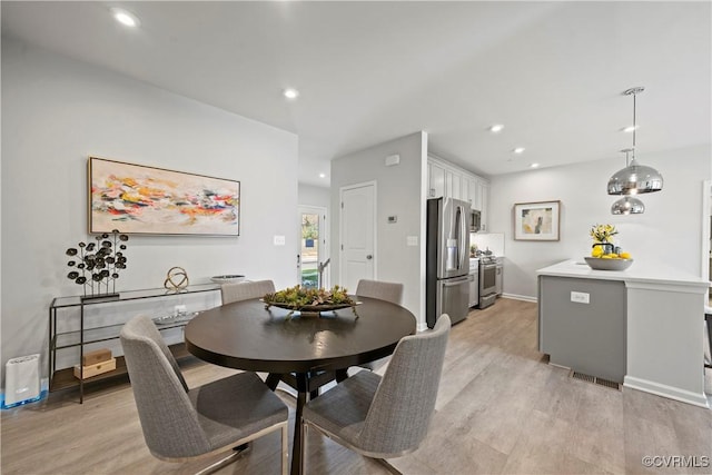 dining room featuring baseboards, light wood-style floors, visible vents, and recessed lighting
