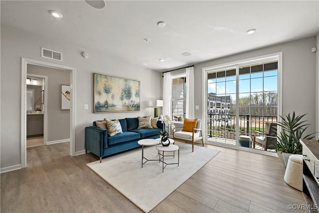 living area featuring visible vents, wood finished floors, baseboards, and recessed lighting