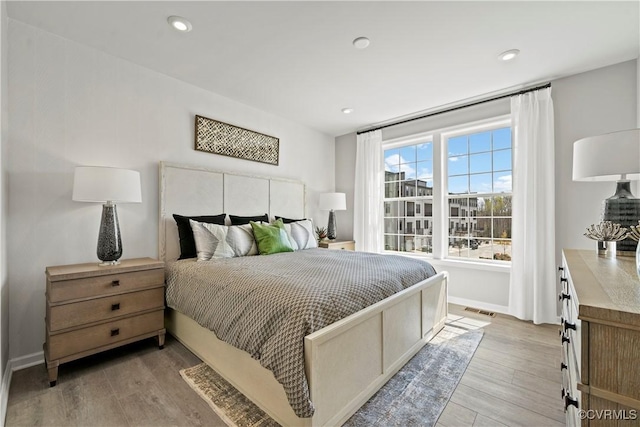 bedroom with baseboards, recessed lighting, light wood finished floors, and visible vents