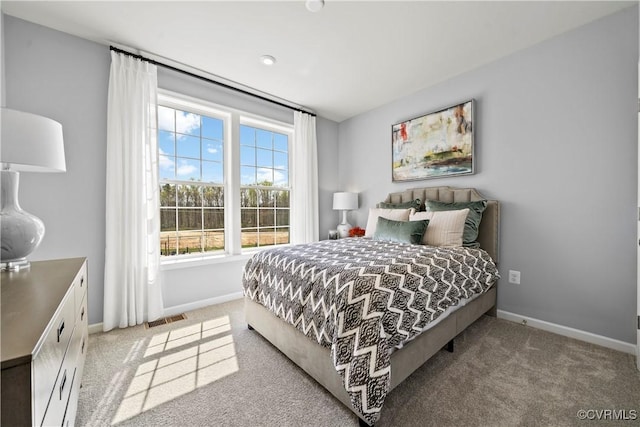 carpeted bedroom featuring baseboards and visible vents