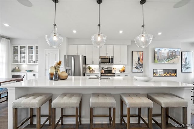 kitchen featuring stainless steel appliances, recessed lighting, a sink, white cabinetry, and light countertops