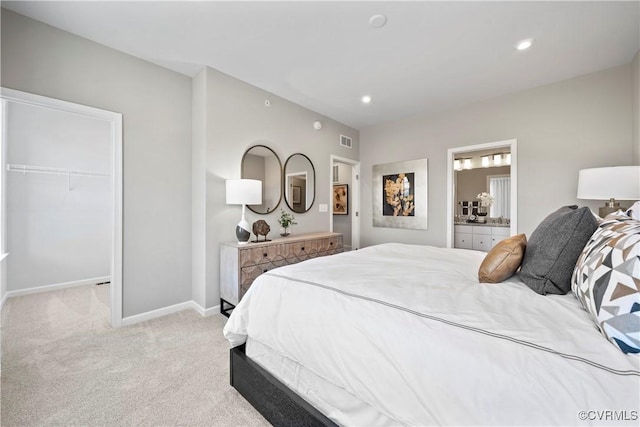 bedroom featuring a closet, visible vents, baseboards, light colored carpet, and a spacious closet