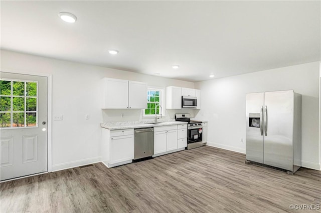 1684 Halls Store Rd, Mineral, VA 23117 - kitchen with baseboards, a sink, stainless steel appliances, white cabinets, and light wood-type flooring