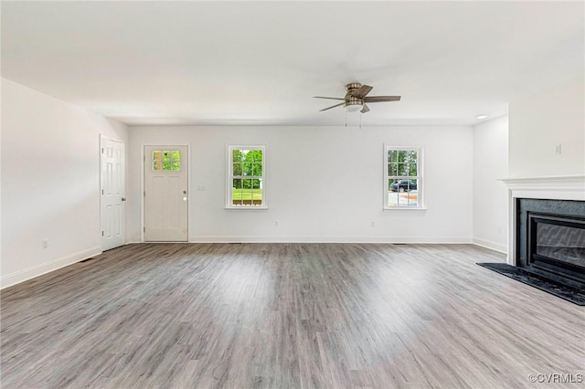 1684 Halls Store Rd, Mineral, VA 23117 - unfurnished living room featuring a ceiling fan, baseboards, a glass covered fireplace, and wood finished floors