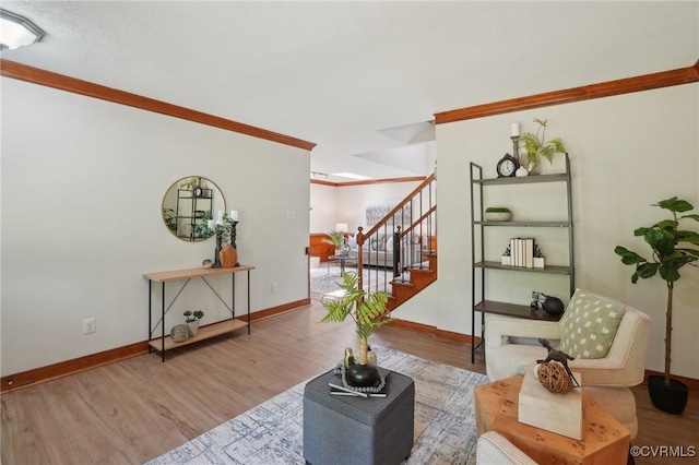 living room featuring baseboards, ornamental molding, stairway, and wood finished floors