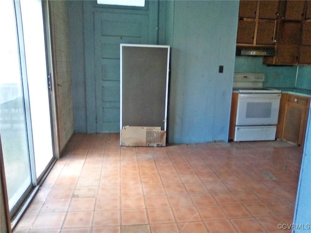 kitchen with range hood, light countertops, light floors, and electric stove