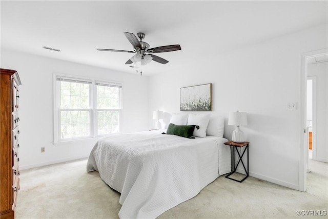 bedroom with light colored carpet, baseboards, and ceiling fan