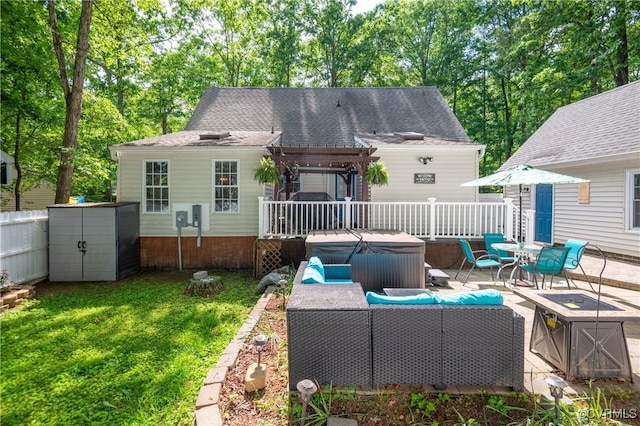 rear view of property with a hot tub, a pergola, a wooden deck, and a shed