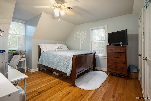 bedroom with vaulted ceiling, light wood-type flooring, a ceiling fan, and baseboards