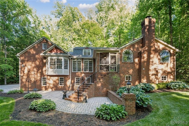 2410 Walhala Dr, North Chesterfield, VA 23236 - back of property with a patio, brick siding, a sunroom, a chimney, and stairs