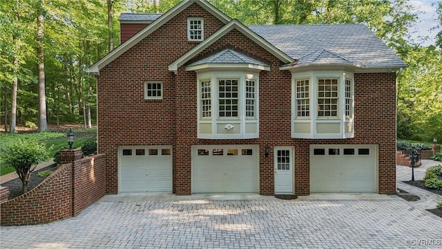 2410 Walhala Dr, North Chesterfield, VA 23236 - view of side of home with an attached garage, brick siding, decorative driveway, and a high end roof