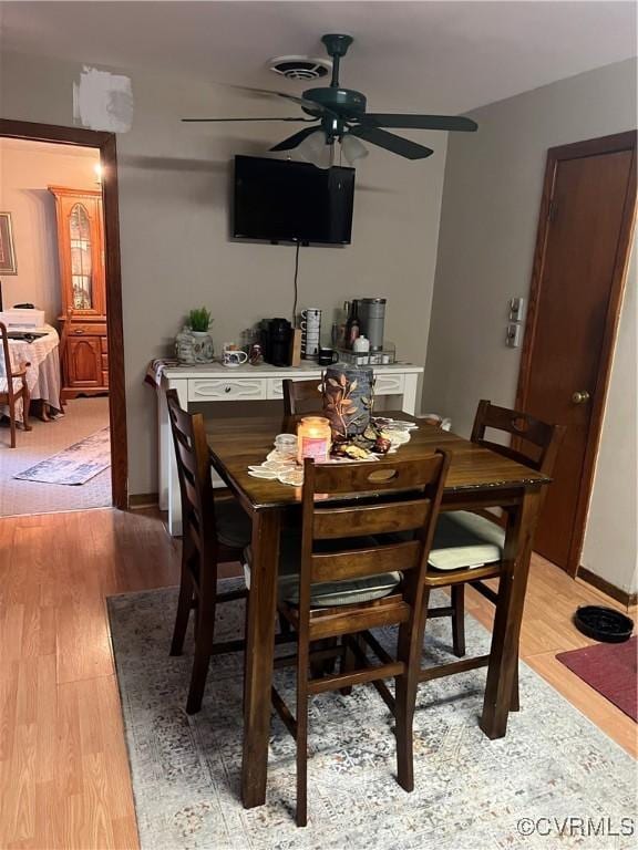 dining space featuring ceiling fan, light wood-style floors, and baseboards