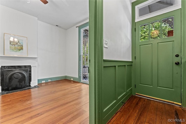 foyer featuring wood finished floors, healthy amount of natural light, and a fireplace with flush hearth