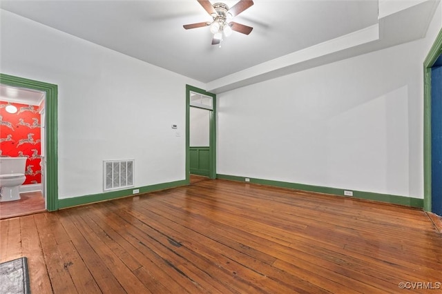spare room with wood-type flooring, ceiling fan, and baseboards