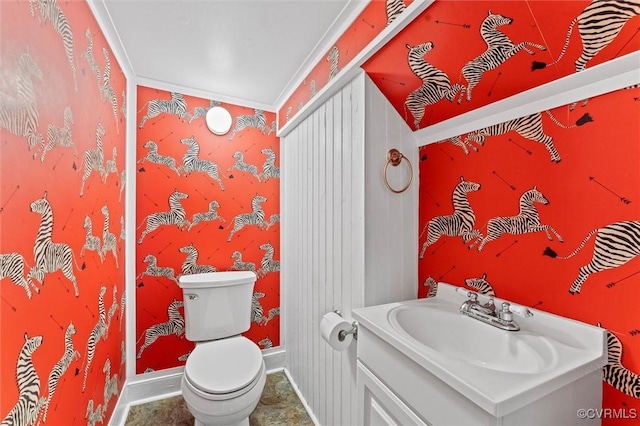 bathroom featuring toilet, vanity, and baseboards