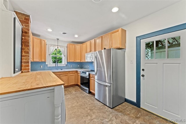 kitchen featuring appliances with stainless steel finishes, light brown cabinets, a sink, backsplash, and recessed lighting