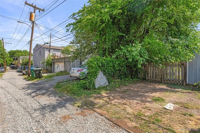 view of yard with fence and gravel driveway