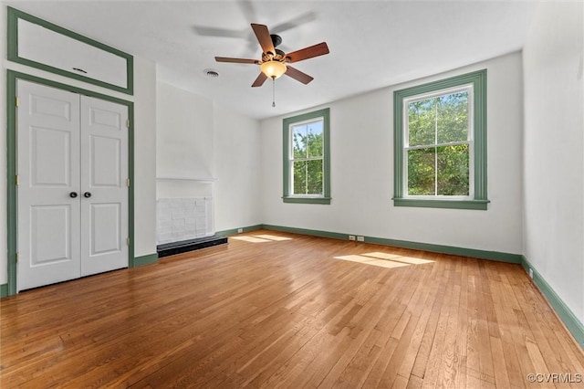 unfurnished bedroom with wood-type flooring, baseboards, ceiling fan, and a closet