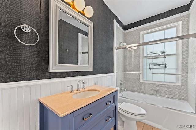 full bath featuring a wainscoted wall, enclosed tub / shower combo, vanity, and toilet