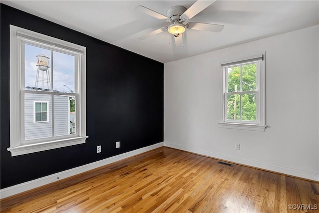 unfurnished room with light wood-style floors, baseboards, and a ceiling fan