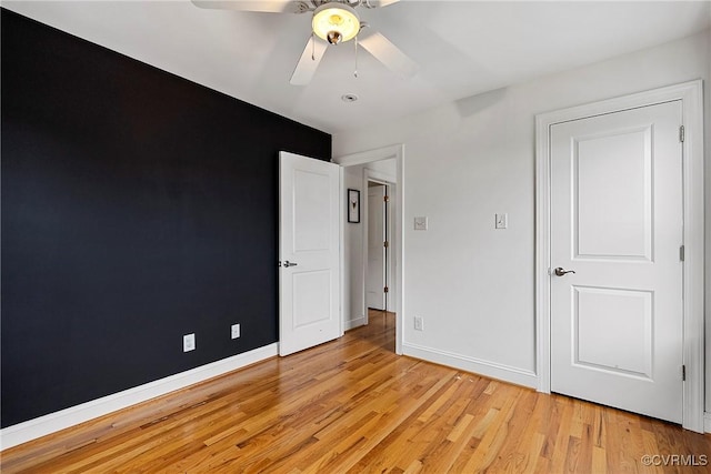 unfurnished bedroom featuring light wood-style flooring, baseboards, and ceiling fan