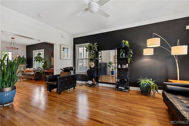 living room featuring ceiling fan, wood finished floors, crown molding, and baseboards