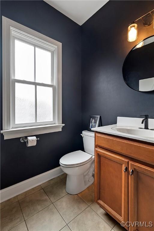 bathroom with tile patterned flooring, toilet, vanity, and baseboards