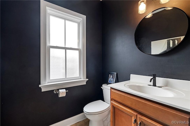 bathroom with toilet, vanity, baseboards, and tile patterned floors