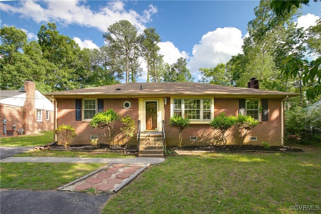 ranch-style home with a front yard, brick siding, crawl space, and a chimney