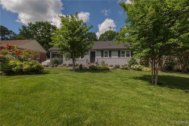 view of front of home featuring a front lawn, entry steps, and a sunroom