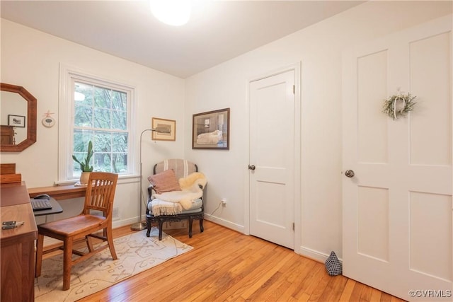 home office with light wood-style flooring and baseboards